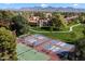 An aerial view showing the community tennis and pickleball courts surrounded by mature trees and desert mountains at 9445 N 94Th Pl # 212, Scottsdale, AZ 85258