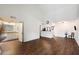 Spacious living room adjacent to vanity and kitchen areas featuring white walls and wood flooring at 9445 N 94Th Pl # 212, Scottsdale, AZ 85258