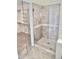 Modern bathroom features a glass-enclosed shower and tiled walls and floors at 11564 W Mule Deer Ct, Surprise, AZ 85378