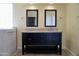 Bathroom featuring a dual sink vanity, granite countertop, dark cabinets, and two large mirrors at 11564 W Mule Deer Ct, Surprise, AZ 85378