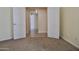 View of a home with neutral color palette and white trim featuring an interior hallway and plush neutral carpeting at 11564 W Mule Deer Ct, Surprise, AZ 85378