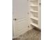 Hall closet interior showing shelving and tile flooring near a white painted paneled door with brushed hardware at 11564 W Mule Deer Ct, Surprise, AZ 85378