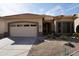 Charming single-story home featuring a two-car garage, desert landscaping, and a tile roof at 11564 W Mule Deer Ct, Surprise, AZ 85378