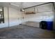 Organized garage interior with a workbench, storage cabinets, and ample space for vehicles and tools at 11564 W Mule Deer Ct, Surprise, AZ 85378