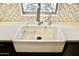 Close up of a white farmhouse sink with modern faucet and window above at 11564 W Mule Deer Ct, Surprise, AZ 85378