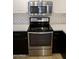 Close up of stainless steel stove and microwave with white subway tile backsplash and white countertops at 11564 W Mule Deer Ct, Surprise, AZ 85378