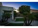 Lush backyard featuring a covered patio, palm trees, a synthetic lawn and concrete paths at 12030 W Louise Ct, Sun City, AZ 85373