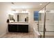 Bathroom featuring a tiled floor, large mirror, double vanity, and tiled shower and tub at 12030 W Louise Ct, Sun City, AZ 85373