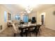 Open dining room with modern table set, chandelier, and seamless flow into the living space at 12030 W Louise Ct, Sun City, AZ 85373