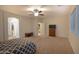 Spacious bedroom featuring a ceiling fan, a window, and doorway to the next room at 12030 W Louise Ct, Sun City, AZ 85373