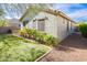 Charming backyard features manicured lawn area with gravel and green shrubbery surrounding stucco home at 12711 W Lowden Rd, Peoria, AZ 85383