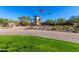 Community clubhouse featuring lush landscaping, green lawns, and American and Arizona state flags at 12711 W Lowden Rd, Peoria, AZ 85383