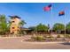 Clubhouse entrance with American and Arizona flags, manicured landscaping, and a tower feature at 12711 W Lowden Rd, Peoria, AZ 85383