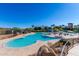 A serene view of the community pool with a uniquely shaped design and seating arrangements for relaxation at 12711 W Lowden Rd, Peoria, AZ 85383