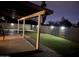 Backyard patio space with covered structure with lighting, grassy area, and brick perimeter wall at 15218 N 37Th Ave, Phoenix, AZ 85053