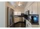 Well-lit kitchen featuring stainless steel appliances and sleek black countertops at 154 W 5Th St # 157, Tempe, AZ 85281