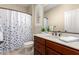 Well-lit bathroom featuring a cherry vanity, granite countertops, and tiled flooring at 16390 W Sheila Ln, Goodyear, AZ 85395