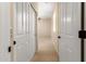 Bright hallway with neutral walls leads to carpeted bedroom with ceiling fan and plantation shutters at 16390 W Sheila Ln, Goodyear, AZ 85395