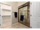 Bathroom featuring walk-in closet access, tiled floor, and a shower with glass doors at 16390 W Sheila Ln, Goodyear, AZ 85395