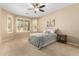 Bedroom with large windows, ceiling fan, and neutral tones, providing a serene and relaxing atmosphere at 16390 W Sheila Ln, Goodyear, AZ 85395