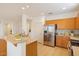 Bright kitchen featuring stainless steel appliances, breakfast bar, and warm neutral tones at 17661 N Saddle Ridge Dr, Surprise, AZ 85374