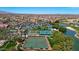 Aerial view of community featuring tennis and lawn bowling courts along with lush desert landscaping and scenic pond at 18102 N Petrified Forest Dr, Surprise, AZ 85374