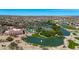 Wide aerial view of community including a pond, golf course, tennis courts, pool, and well-manicured lawns at 18102 N Petrified Forest Dr, Surprise, AZ 85374