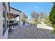 Wide view of a shaded back patio with ceiling fans and furniture, connected to a gravel area and landscaping at 18102 N Petrified Forest Dr, Surprise, AZ 85374