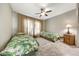 Bright bedroom features two twin beds with leafy bedding, a ceiling fan, and light tile flooring at 18102 N Petrified Forest Dr, Surprise, AZ 85374