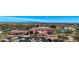 Aerial view of a clubhouse showing desert landscaping, large windows, and a tranquil pond at 18102 N Petrified Forest Dr, Surprise, AZ 85374