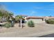 Charming single-story home with desert landscaping, a tile roof, and a two-car garage at 18102 N Petrified Forest Dr, Surprise, AZ 85374