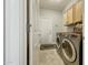 Laundry room boasts a modern washer and dryer, overhead cabinets, and a side entry door at 18102 N Petrified Forest Dr, Surprise, AZ 85374