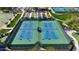 Up close aerial view of a community tennis court with new resurfaced blue courts and green fencing at 18102 N Petrified Forest Dr, Surprise, AZ 85374