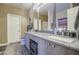 Bathroom features double sinks, granite counters, wood-look floors, and great lighting at 188 E Mountain View Rd, San Tan Valley, AZ 85143