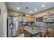 Kitchen with stainless steel refrigerator, granite countertops, wood cabinets and mosaic tile backsplash at 188 E Mountain View Rd, San Tan Valley, AZ 85143