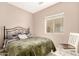 Cozy bedroom with a comfortable bed, a wrought iron headboard, and a sunlit window view at 20551 N 262Nd Ave, Buckeye, AZ 85396