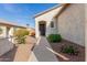 Home entrance with decorative rock landscaping, sidewalk, and desert foliage at 20551 N 262Nd Ave, Buckeye, AZ 85396