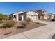 Charming single-story home featuring a two-car garage, desert landscaping, and neutral stucco exterior at 20551 N 262Nd Ave, Buckeye, AZ 85396