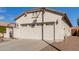 Garage of home featuring windows, exterior lights, and desert landscaping in front at 20551 N 262Nd Ave, Buckeye, AZ 85396