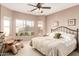 Bright and airy main bedroom with large windows, a ceiling fan, and a comfortable seating area at 20551 N 262Nd Ave, Buckeye, AZ 85396