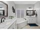 Luxurious bathroom with dual sinks, soaking tub, and natural light at 21921 E Domingo Rd, Queen Creek, AZ 85142