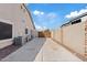 Long concrete driveway that leads to the backyard gate and AC units at 21921 E Domingo Rd, Queen Creek, AZ 85142