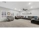 Inviting living room featuring a gray sectional, plush carpet, and bright, airy atmosphere at 21921 E Domingo Rd, Queen Creek, AZ 85142