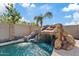 Rock waterfall and slide feature adds a unique touch to the backyard pool at 21921 E Domingo Rd, Queen Creek, AZ 85142