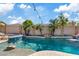 Backyard pool features rock accents, a slide and several mature palm trees at 21921 E Domingo Rd, Queen Creek, AZ 85142