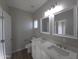 Bright bathroom featuring a double vanity with quartz countertops and chrome fixtures and tile floors at 26409 W Desert Crest St, Casa Grande, AZ 85193