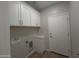 Bright laundry room featuring ample cabinet storage, utility sink hookups, and a door to the exterior at 26409 W Desert Crest St, Casa Grande, AZ 85193