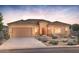 Beautiful single-story home with desert landscaping, a two-car garage, and a tile roof at dusk at 26664 W Siesta Ln, Buckeye, AZ 85396