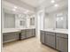 Spacious bathroom featuring double vanities with gray cabinets, white countertops, and large mirrors at 26903 W Renee Dr, Buckeye, AZ 85396