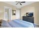 View of a light-filled bedroom with ceiling fan and a dresser with television at 27000 N Alma School Pkwy # 1032, Scottsdale, AZ 85262